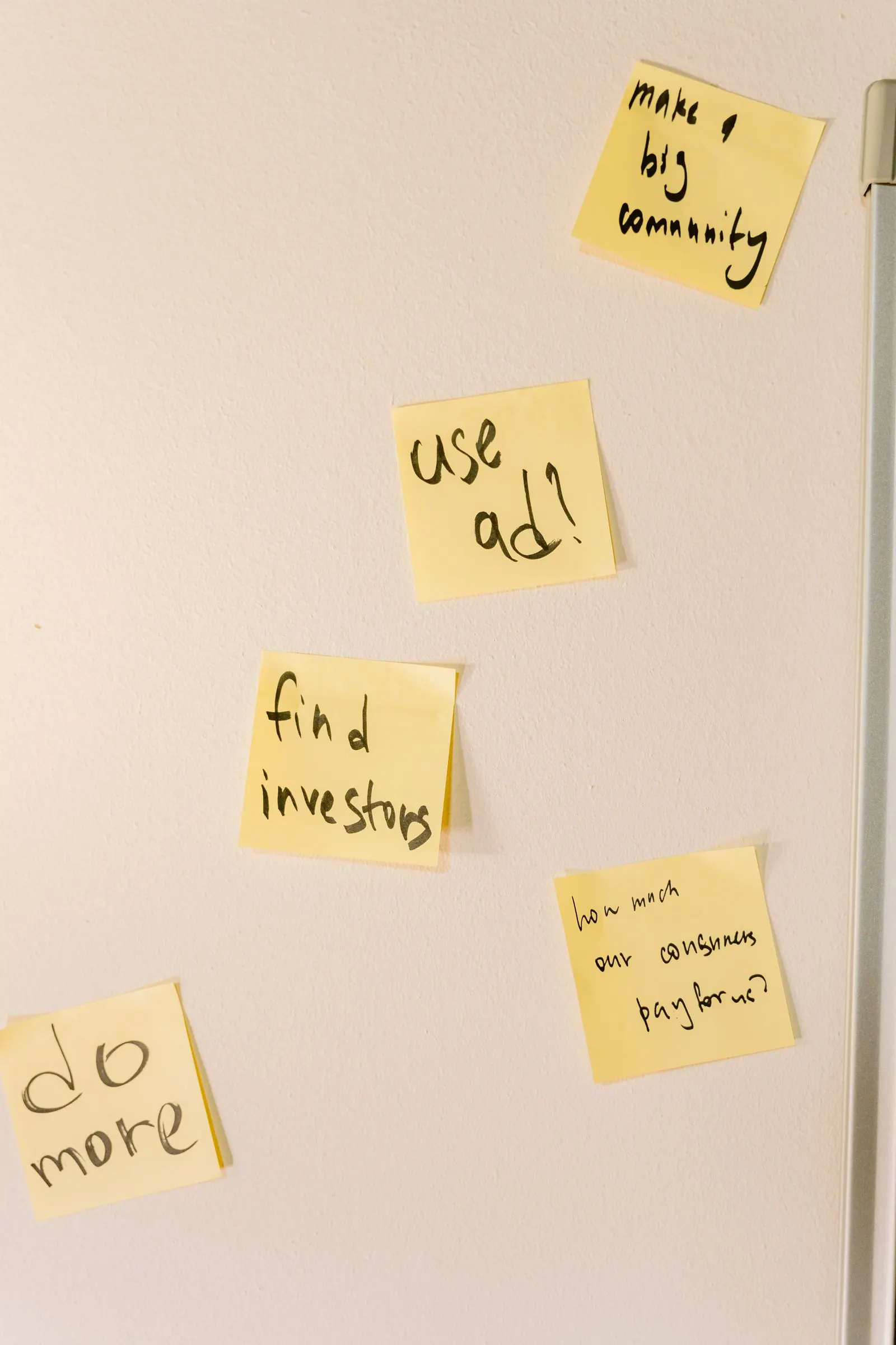 Yellow notes reading goals and ideas are arranged on a warm coloured wall.