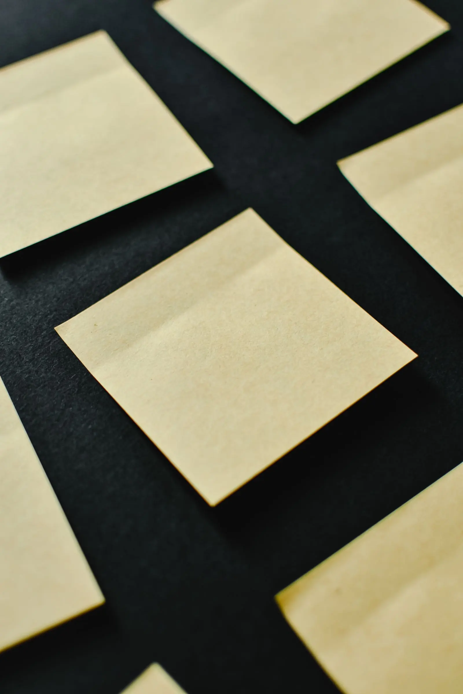 Blank yellow sticky notes are arranged separately on a dark background.